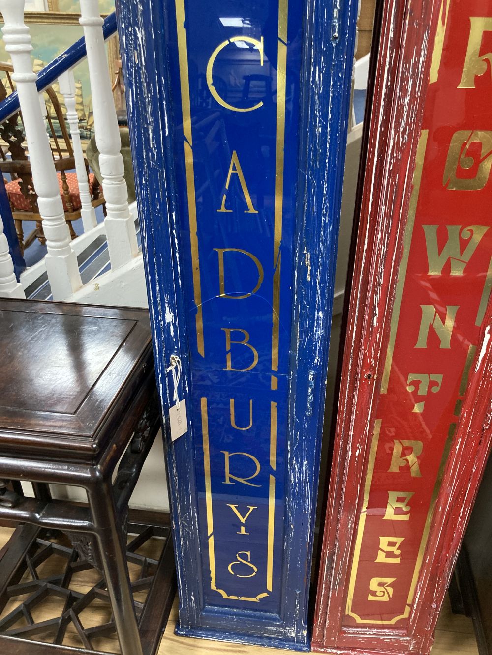 Two painted wood shop display cabinets, the glass doors marked Cadburys and Rowntrees, largest width 34cm height 140cm